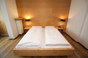 慕尼黑海格尔酒店的木房的一张床位,墙上有两盏灯