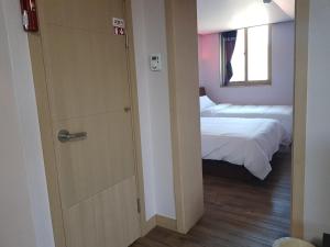 平昌Hyundai Elliot Hotel and Resort的卧室设有通往床和窗户的门