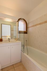 拉萨尔莱阿尔佩阿尔平花园小木屋旅馆的浴室配有水槽、淋浴和浴缸。