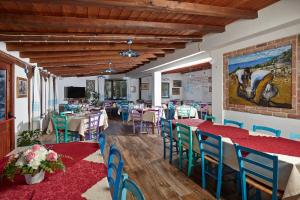 卡拉古诺内Agriturismo Codula Fuili的餐厅设有桌椅,墙上挂有绘画作品