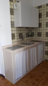 罗迪-加尔加尼科Oasi Agrumeto的厨房配有水槽和白色橱柜