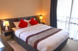 陶波巴塞罗那汽车旅馆的一间卧室配有一张带红色枕头的大床