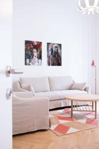 维也纳HeyMi Apartments Stephansdom的客厅配有白色沙发和墙上的三张照片