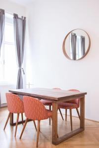 维也纳HeyMi Apartments Stephansdom的餐桌、椅子和镜子