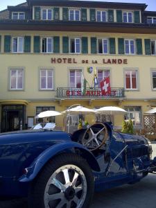 勒布拉索斯兰德酒店的停在酒店前的一辆旧蓝色汽车