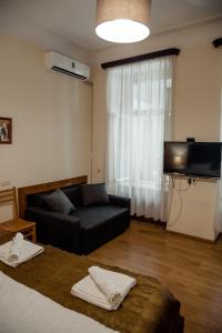 第比利斯Tbilisi Apartment 2的客厅配有黑色沙发和电视