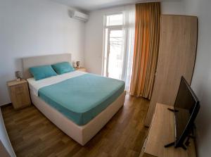 多布拉沃达Queen Apartments & Rooms的一间卧室设有一张大床和一个窗户。