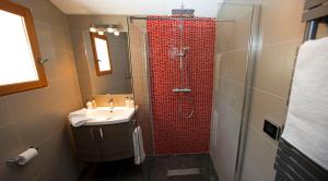 勒卡斯特雷特马斯德斯阿弗林斯别墅的一间带红色淋浴和盥洗盆的浴室