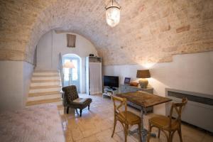 莫诺波利HelloApulia - Peperoncino的客厅配有桌椅和砖墙