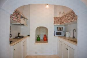 莫诺波利HelloApulia - Peperoncino的厨房内的拱门,配有水槽和微波炉