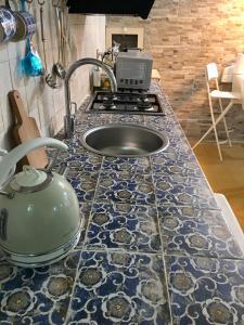 锡拉库扎Il Sipario Palazzo Accolla的厨房柜台设有水槽和炉灶。