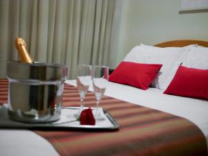 尼泰罗伊伊卡拉海滩酒店的一间酒店客房,配有一张带两个玻璃杯的床铺,托盘