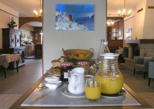 欧迪耶讷Auberge du Cabestan Hotel Audierne的桌子上放着一壶果汁和眼镜