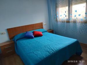 维拉波Nores Buenavista的一间卧室配有蓝色的床和红色和蓝色枕头