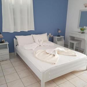 考弗尼西亚Melissa Rooms的卧室内的白色床和毛巾