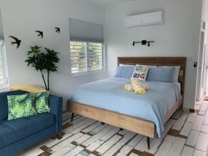 林康The Beach Pad的一间卧室配有一张床和一张蓝色的沙发