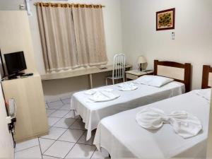 布拉干萨-保利斯塔Vinte Park Hotel的酒店客房设有两张床和电视。