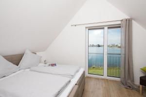 奥尔本尼兹Sunshine的一间卧室设有一张床和一个大窗户