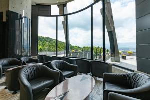 御殿场市Rembrandt Premium Fuji Gotenba的餐厅设有桌椅和大窗户。