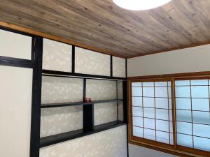 冲绳岛市Condominium WAFU TEI Okinawa city的客房设有窗户和木制天花板。