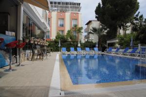 安塔利亚古登珍珠公寓的一座带蓝色椅子的游泳池和一座建筑