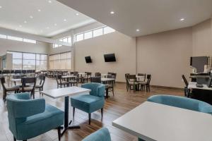 俄克拉何马城MainStay Suites Bricktown - near Medical Center的用餐室配有桌椅和窗户。