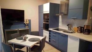 格拉尔-米里茨Ostsee-Kay的厨房配有蓝色橱柜、桌子和水槽