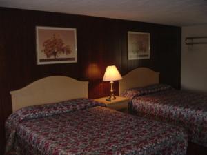 Clarence费尔斯三皇冠汽车旅馆 的酒店客房,设有两张床和一盏灯