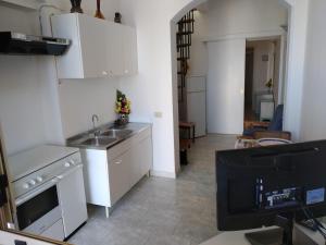 帕图casa dolce casa的一间带白色橱柜和水槽的厨房以及一台电视