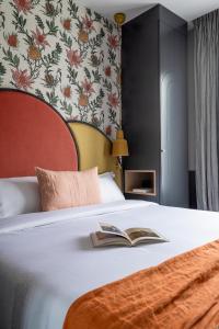 巴黎Hôtel Léopold - Orso Hotels的一间卧室配有一张床,上面有一本书