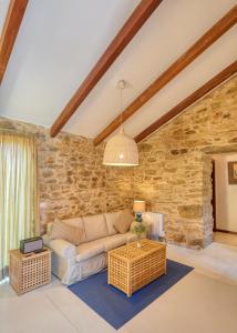 内安诺Pedracuca - Costa da Morte的带沙发和石墙的客厅