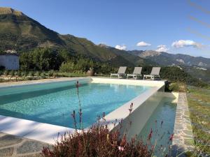 巴尼－迪卢卡Luxurious Holiday Home in Bagni di Lucca with Pool的一个带椅子的游泳池,背景是山脉
