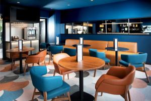 莫尔塞姆Hotel Le Bugatti的餐厅拥有蓝色的墙壁和桌椅