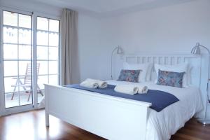 丰沙尔Heritage Apartments的卧室配有带毛巾的大型白色床