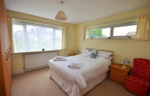 海景城Solent View的一间卧室配有一张床和一张红色椅子