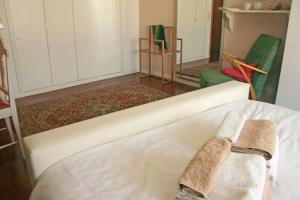 马托西纽什Apartamento Independente Praia & Porto - Limpo e Seguro的一张床上,里面放着两条毛巾
