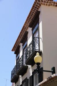 丰沙尔Heritage Apartments的一座设有黑色阳台和街灯的建筑