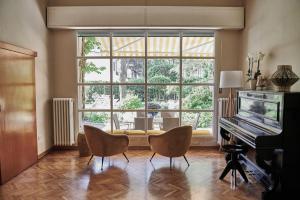 米兰马瑞提那Villa Arizona的客厅配有钢琴和大窗户