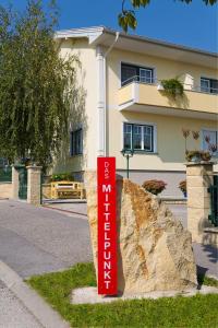 滨湖默尔比施Appartementhaus Das Mittelpunkt的一块大石头前面的红色标志