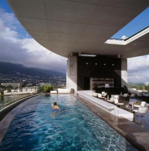 蒙特雷Habita Monterrey, a Member of Design Hotels的建筑物屋顶游泳池里的人