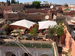 马拉喀什Riad Abaka hotel & boutique的一座带遮阳伞和桌子的庭院