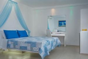 阿达玛斯亚历山德罗斯农庄饭店的一间卧室配有一张带蓝色床单和镜子的床
