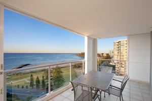 黄金海岸库兰加塔蓝色C公寓式酒店的阳台配有桌椅,享有海景。
