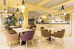 贝尔格莱德Xenon Hotel & SPA的一间带桌椅的餐厅和一间酒吧