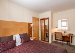 爱丁堡荷里路德公寓酒店的酒店客房配有一张床、一张书桌和一张书桌。