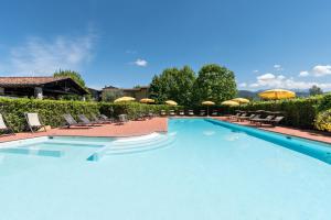 萨尔扎纳安蒂科卡萨莱酒店的一个带椅子和遮阳伞的大型游泳池