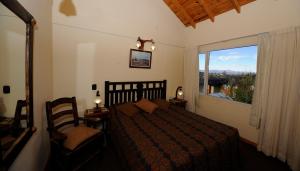 圣卡洛斯-德巴里洛切南桥宾馆的一间卧室设有一张床和一个大窗户