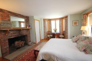 AndoverHighland Lake Inn的一间卧室配有一张床和一个壁炉