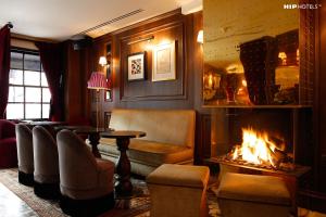 伦敦索和米米酒店的客厅设有壁炉、桌子和椅子