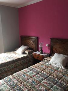 San Martín de LuiñaMRZ Rentals San Martín de Luiña的紫色墙壁客房的两张床